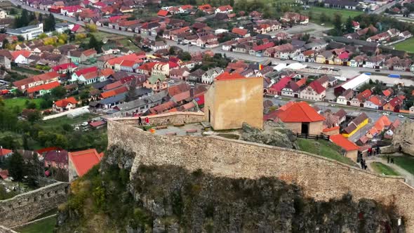 Aerial drone view of Rupea Fortress, Romania. Citadel located on a cliff, tourists, town alt
