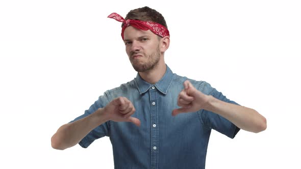 Handsome Stylish Guy with Red Headband Denim Shirt Looking Unamused and Reluctant Showing Thumbsdown