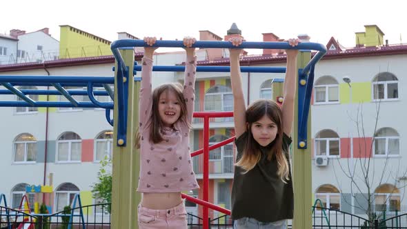 Little Children Playing on the Playground Hanging on the Horizontal Bar Crossbar