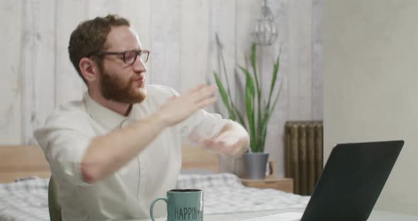 Handsome Bearded Man Working and Dancing at Laptop at Home