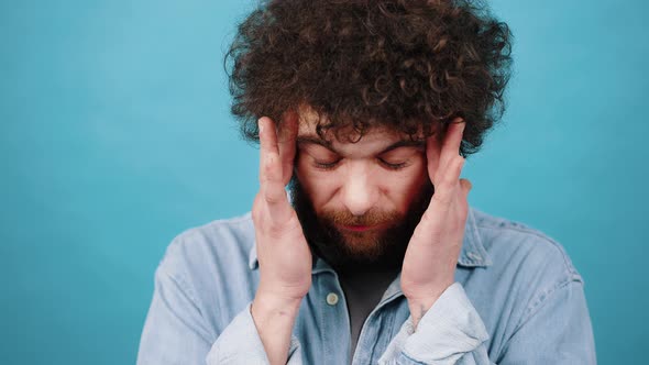 Young Man Massages Temples Suffering From Headache alt