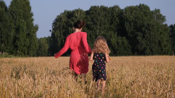 Little Girl with Mother Running Through a Field alt