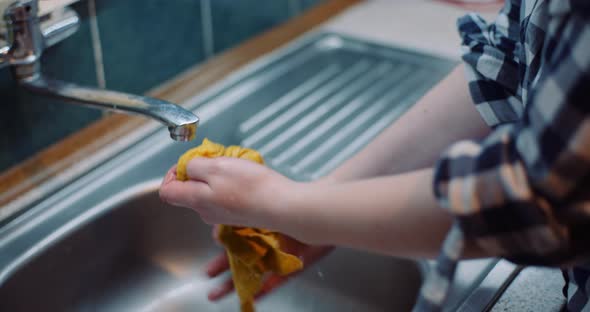 Woman Washing Napkin At Sink alt