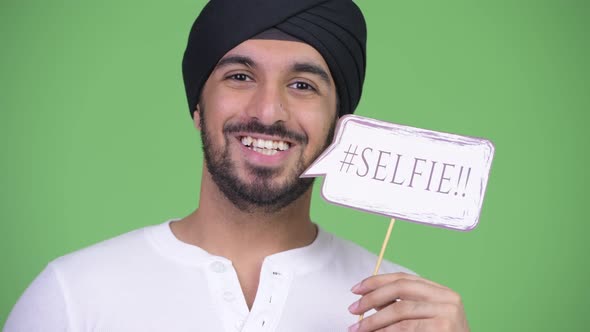 Young Happy Bearded Indian Man with Selfie Paper Sign