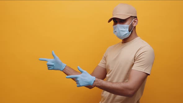 Indian Man with Medical Mask and Gloves Pointing Fingers on Empty Space alt