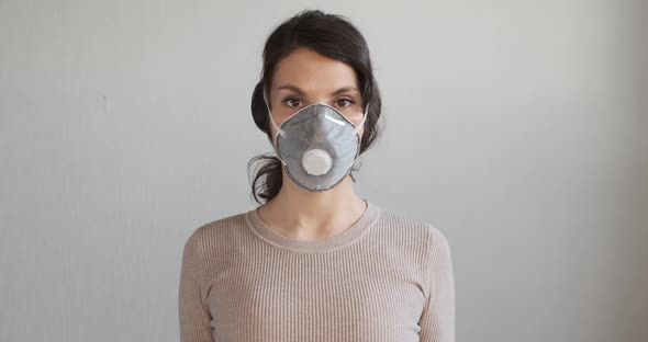 Young Woman Shows How To Wear Protective Medical Mask. Beautiful Girl Shows Protective Mask During alt