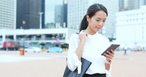 Woman look at mobile phone in city alt