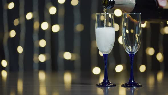 Glasses with champagne for New Year and Christmas on a flickering background