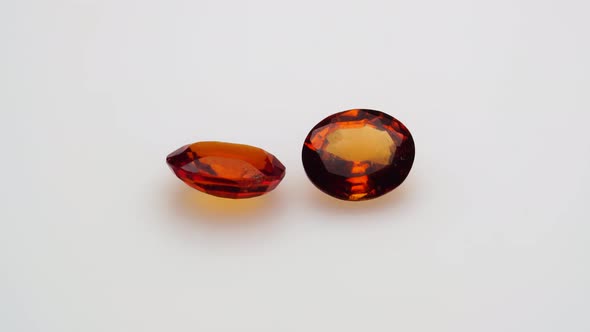 Natural Red Hessonite Garnet Gemstone on the White Background on the Turning Table
