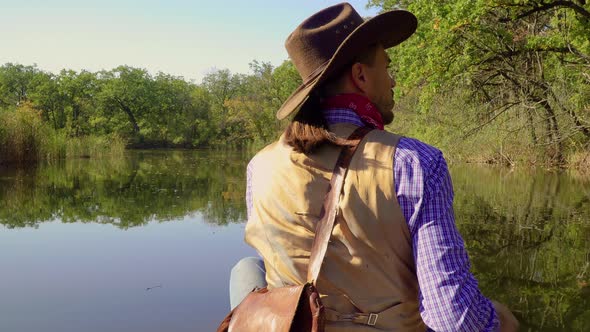 Cowboy in a Canoe Floats on the River alt