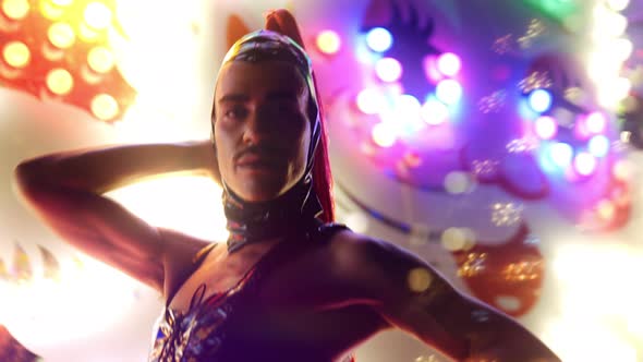 Man With Red Ponytail And Pvc Posing By Neon Lights alt