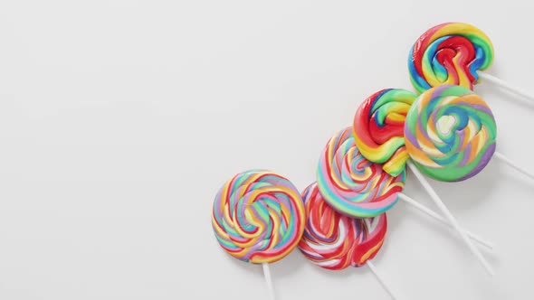 Video of rows multicoloured lollipops on white background alt