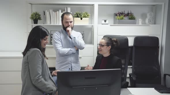 Business colleagues discussing data on computer alt