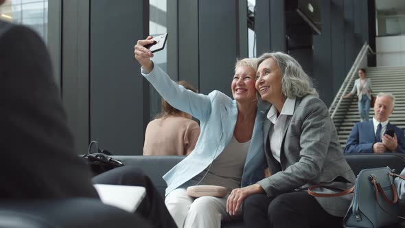 Two Middle-aged Female Friends Making Selfie in Airport alt