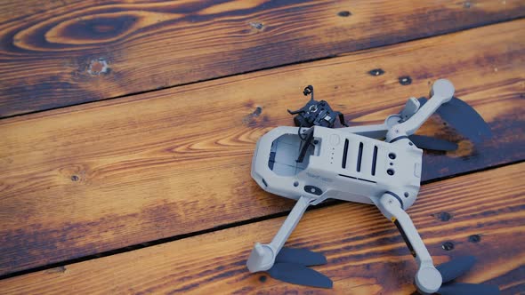 Crashed Drone on the Old Wooden Background with a Broken Camera alt