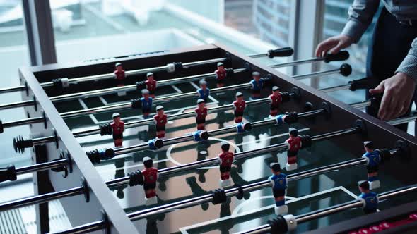 Office Workers Take a Break From Routine Work with a Table Game of Football