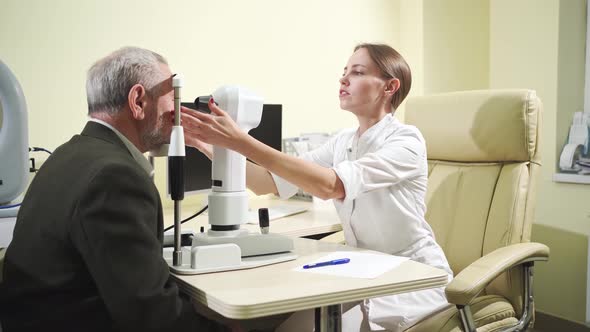 Ophthalmologist Examination of Elderly Man on Corneo Topographer alt