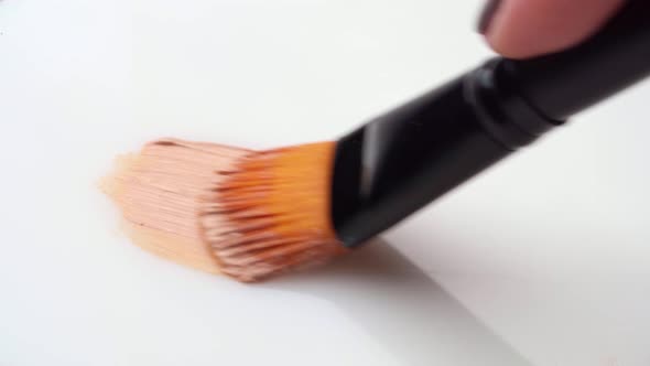 Facial Foundation Smudge Made with a Brush on White Makeup Palette Close Up alt