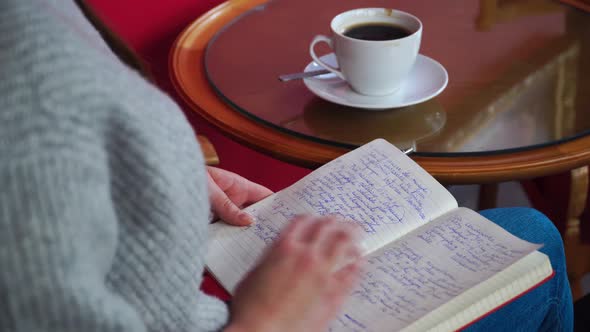 Girl Sitting with Notepad and Drink Coffee at the Table