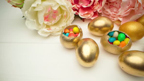 Golden Decorative Easter Eggs Filled with Colorful Candies on Wooden Table Close Up