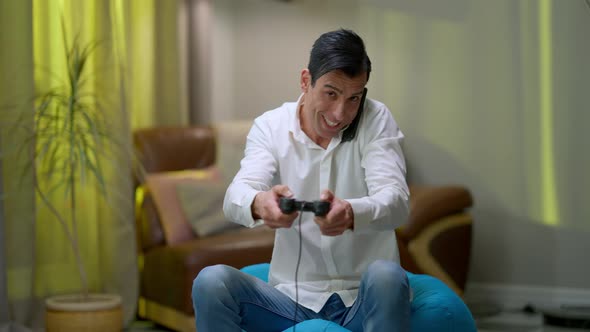 Gaming Addicted Middle Eastern Man Talking on the Phone Playing with Game Control alt
