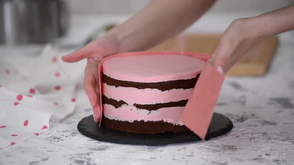 Pastry making patisserie baking confectioner: Decorating cake with pink chocolate.