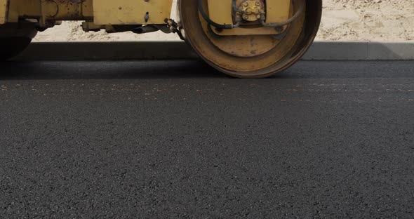 A Large Yellow Steamroller Flatten Hot Asphalt. Builds A New Road alt