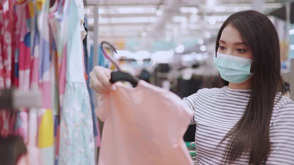 Young Asian woman in medical mask grocery walk toward camera shot, at supermarket alt