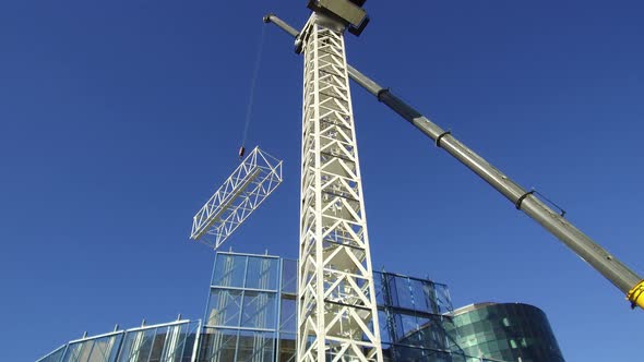 Crane being constructed in sections by smaller crane. Lifting the crane segments into place alt