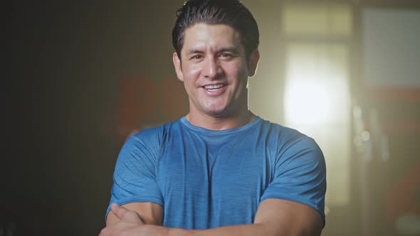 Close-up of Caucasian young male athlete or sportsman standing in the dark of training stadium. alt