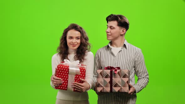 A Man and a Woman are Holding Gifts alt
