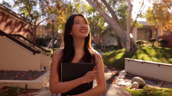 Asian female college student walking toward the camera alt