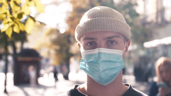 Close Up of Face of Young Caucasian Handsome Man in Medical Mask Looking Straight To Camera alt