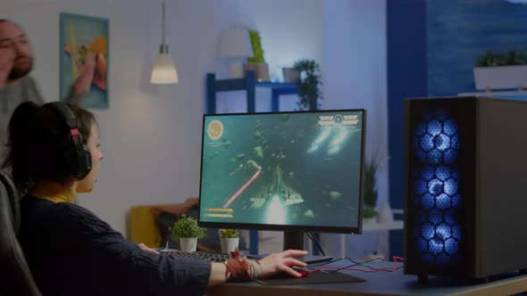 Nervous Man Screaming at Woman While She is Playing Space Shooter Video Game alt