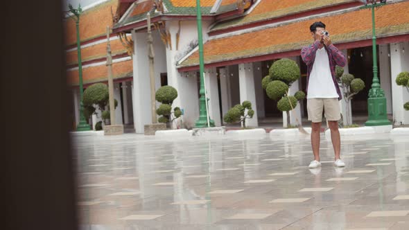 Attractive young Asian man solo tourists walking and looking around inside the temple.