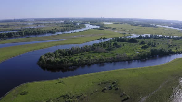 Scenic Aerial View of a River and Green Fields in a Countryside