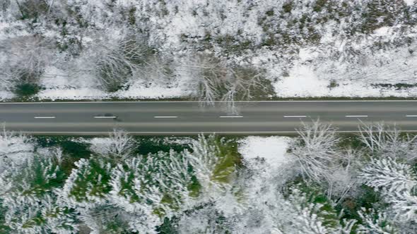 Flying along a nearly empty street on a cold winter day with snow covered trees at times of corona a alt