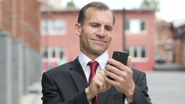 Portrait of Businessman Busy Using Smartphone alt