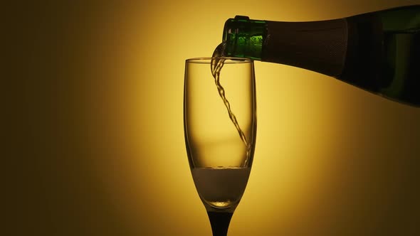 Champagne Pouring in Glass at Yellow Background alt