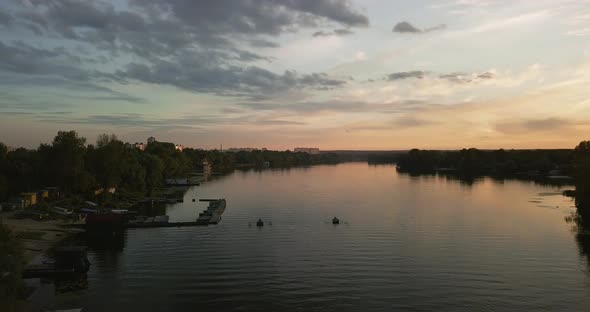 Drone Flight Over the Fishermen and the Boat Station, at Sunset Over the River. Beautiful Sky