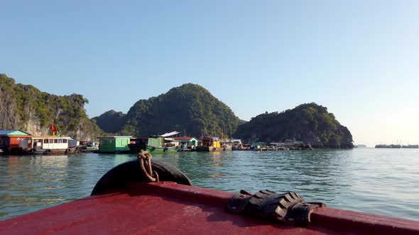 Approaching boats parked on Ha Long Bay Vietnam on the deck of a small vessel, Handheld stable shot alt