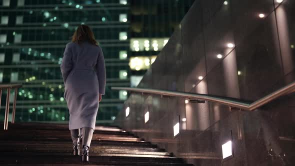 Townswoman is Dressed Warm Coat for Fall Season is Walking in City in Evening Going Up Over Stair alt
