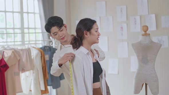 Man Tailor Takes Measures With Female Models. Fashion Designer Sews A Costume For The Model alt