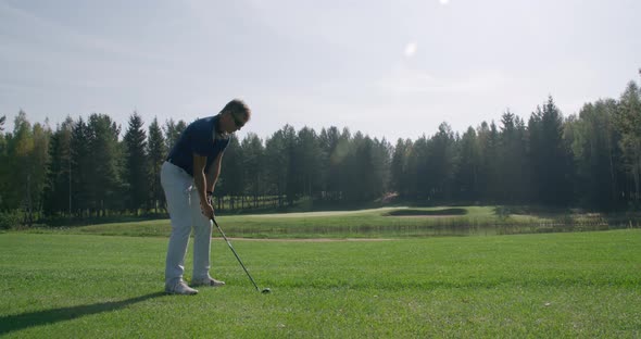 Summer Day, Man Playing Golf, Hits the Ball, View of Golf Course in Forest Area, Green Lawnm, Slow alt