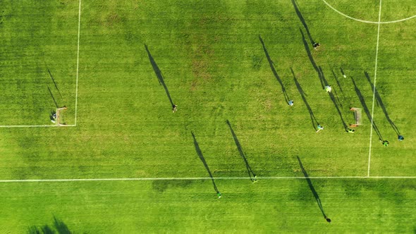 Aerial Top Down View Green Mini Football Field Children Running with Ball alt