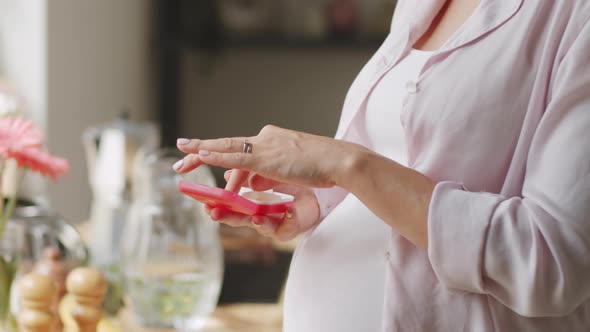 Pregnant Woman Taking Pills at Home alt