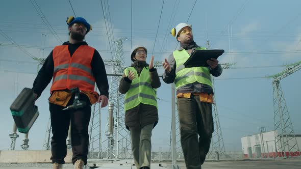 Employees Walk Along Power Substation and Discuss Project