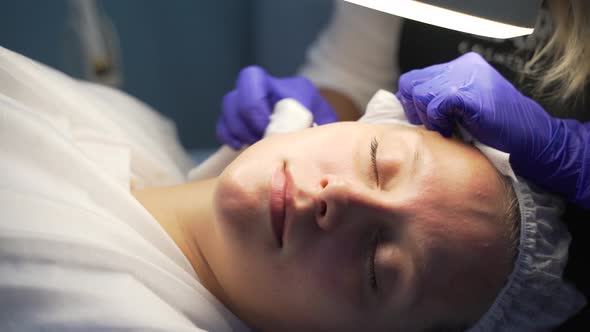 Doctor Squeezes Out Pimples on Face of Woman alt