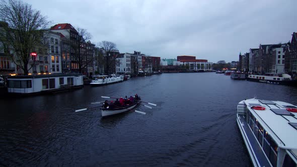 Amsterdam, Holland, Rowers and boat in water canal, Wide static shot, blue hour alt