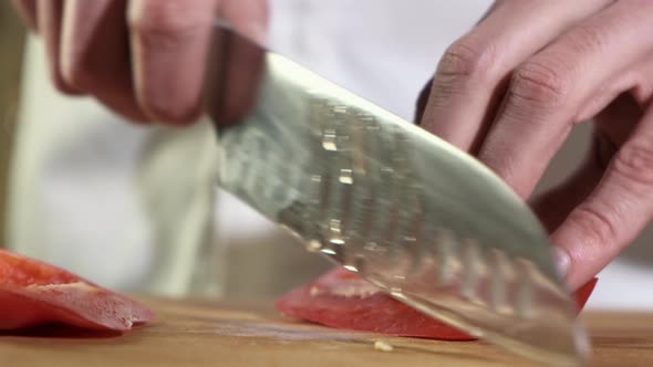 Cook cuts fresh ripe red peppers with sharp knife alt